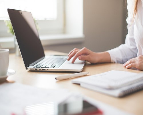 Colombian professional working comfortably on a laptop near a bright window